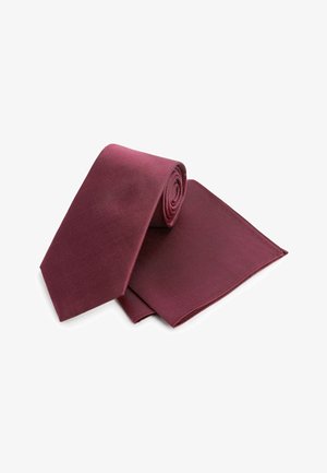 Cravate en soie bordeaux roulée avec un mouchoir de poche assorti. La cravate a une texture lisse et un design classique effilé.
