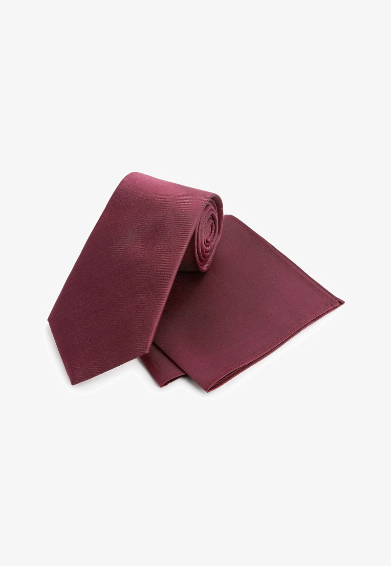 Cravate en soie bordeaux roulée avec un mouchoir de poche assorti. La cravate a une texture lisse et un design classique effilé.