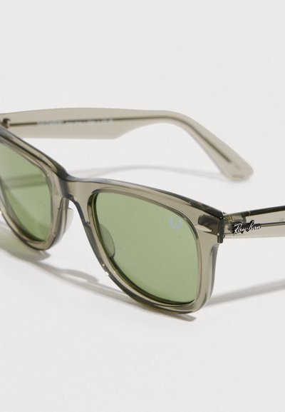 Слънчеви очила Ray-Ban с полупрозрачна сива рамка, зелени стъкла и сребристи акценти; с характерното лого на дръжките.