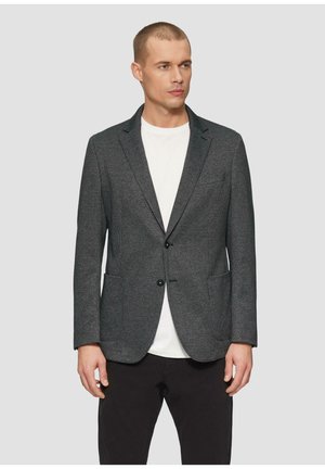Grau strukturierter Blazer mit zwei vorderen Taschen, einem Ein-Knopf-Verschluss und geschlitztem Revers, kombiniert mit einem weißen T-Shirt und dunklen Hosen.
