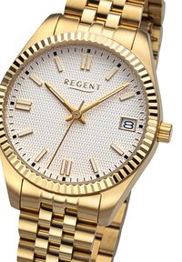 Montre dorée avec un cadran texturé blanc, des index horaires dorés et des accents noirs. Présente un affichage de la date et un bracelet en métal tressé.