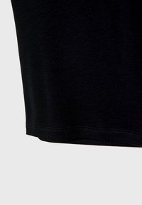 Tissu noir côtelé avec une texture lisse, présentant un ourlet droit propre et des détails de couture subtils aux bords.