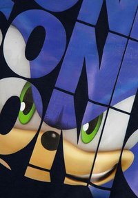 Granatowa koszulka z nadrukiem postaci kreskówkowej z niebieskimi włosami, zielonymi oczami i uroczym uśmiechem, na której znajduje się odważny, graficzny tekst.