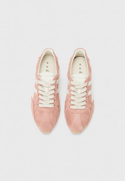 Sneaker in suede rosa con strisce e lacci bianchi, caratterizzati da una punta rotonda e una parte superiore testurizzata. Design atletico classico e suola in gomma.