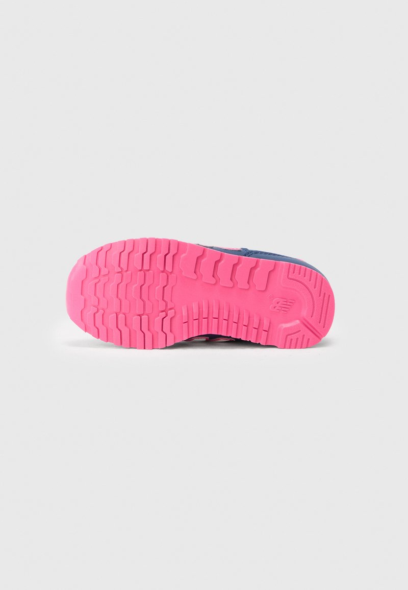 Semelle de chaussure avec un design texturé, présentant un matériau en caoutchouc rose vif et de profondes rainures pour une excellente adhérence. Partie supérieure bleue visible sur le bord.