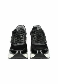 Black sneakers with a mix of suede and patent leather, featuring a thick white sole, round laces, and a padded collar for comfort.