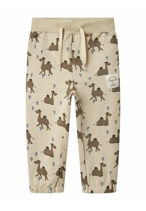 Pantaloni jogger beige con un motivo cammello e cactus blu. Presentano una vita elasticizzata con cordino e caviglie con orli.