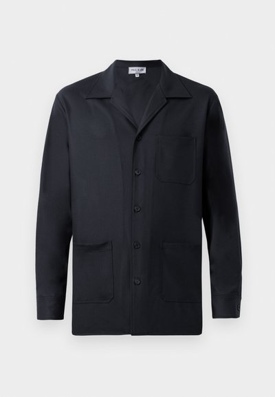 Jachetă neagră din țesătură netedă, cu un guler cu vârfuri, butoni frontali și două buzunare frontale. Design minimalist.