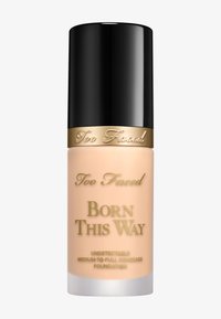 Too Faced Born This Way foundation in een matte glazen fles met een zwarte dop en gouden accenten. Tekst op de fles geeft het dekkingsniveau aan.
