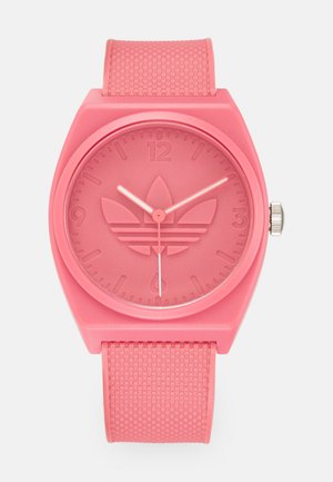 Roosa silikoonkell tekstuuriga rihmaga, ümmargune korpus ja reljeefne logo. Omab minimalistlikke tunni tähiseid ja sujuvat sekundinäidikut.