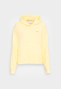 Felpa gialla oversize realizzata in materiale morbido, con tasca a marsupio, cappuccio con cordino e un dettaglio del marchio minimalista sul davanti.
