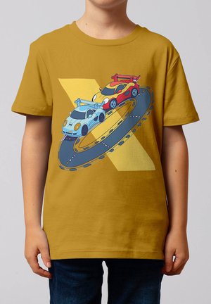 Kind trägt ein senfgelbes T-Shirt mit einem Motiv von blauen und roten Rennwagen, die auf einer geschlungenen Rennstrecke rasen.