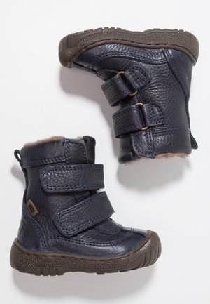 Bottes pour tout-petit en cuir bleu foncé texturé avec semelles en caoutchouc marron, double bride auto-agrippante, et doublure en polaire à l'intérieur.