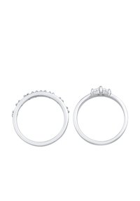 To sølvringer vises. Den ene har en række små sten, mens den anden har en trio af større sten sat ovenpå.