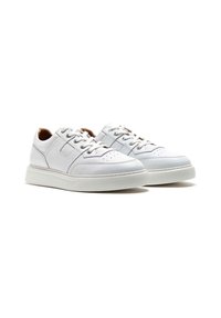 Sneakers bianchi con tomaia a superficie liscia, chiusura con lacci, dettagli perforati sulla punta e una spessa suola in gomma bianca.