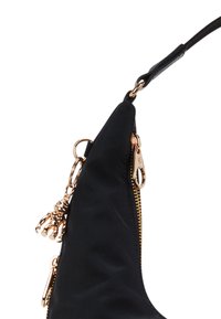 Borsa nera con un design elegante, caratterizzata da hardware in tonalità dorata, zip e un charm a forma di orso. Realizzata in un tessuto liscio.