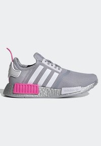 Sneaker Adidas gris avec des rayures blanches, semelle argentée, accents de talon rose vif et tige en maille, montré de côté sur un fond clair.