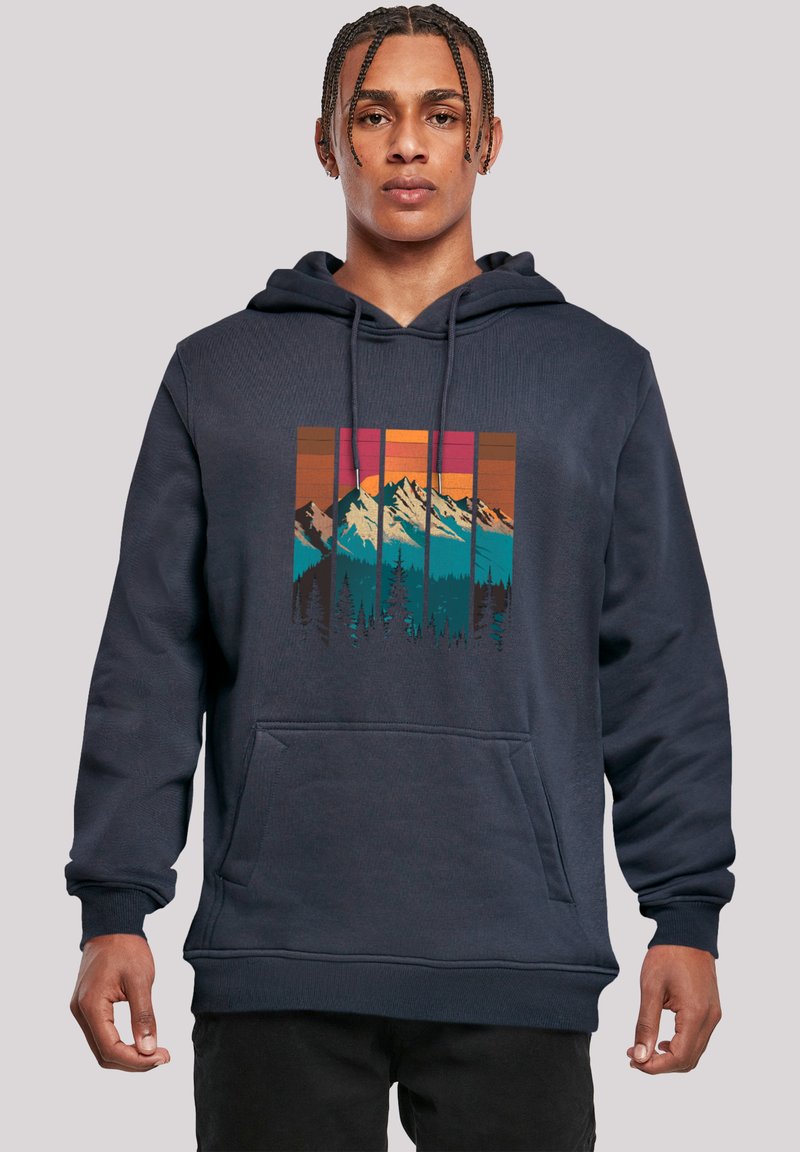 Navy blue hoodie with a front pocket, featuring a colorful mountain and forest graphic in rectangular panels. Soft fabric, relaxed fit.