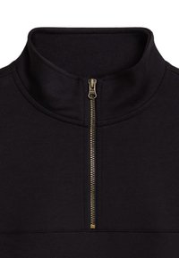 Schwarzer Pullover mit hohem Kragen und goldenem Reißverschluss. Der Stoff wirkt weich mit einer glatten Textur und sauberen Nähten entlang der Nähte.