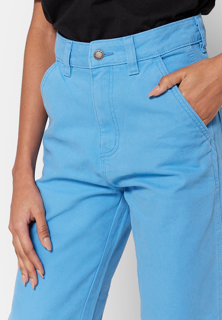 Pantaloni in cotone blu con design a gamba dritta, tasca frontale e chiusura con bottone metallico in vita. Dettaglio in tessuto testurizzato.