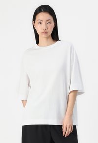 Witte oversized t-shirt gemaakt van zachte katoen, met een ronde halslijn, korte mouwen en een relaxte fit. Geen zichtbare patronen of graphics.