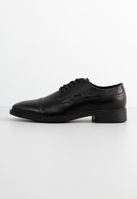 Scarpa da uomo in pelle nera con punta arrotondata, design con lacci, superficie liscia e tacco impilato. Stile minimalista con dettagli di cucitura discreti.