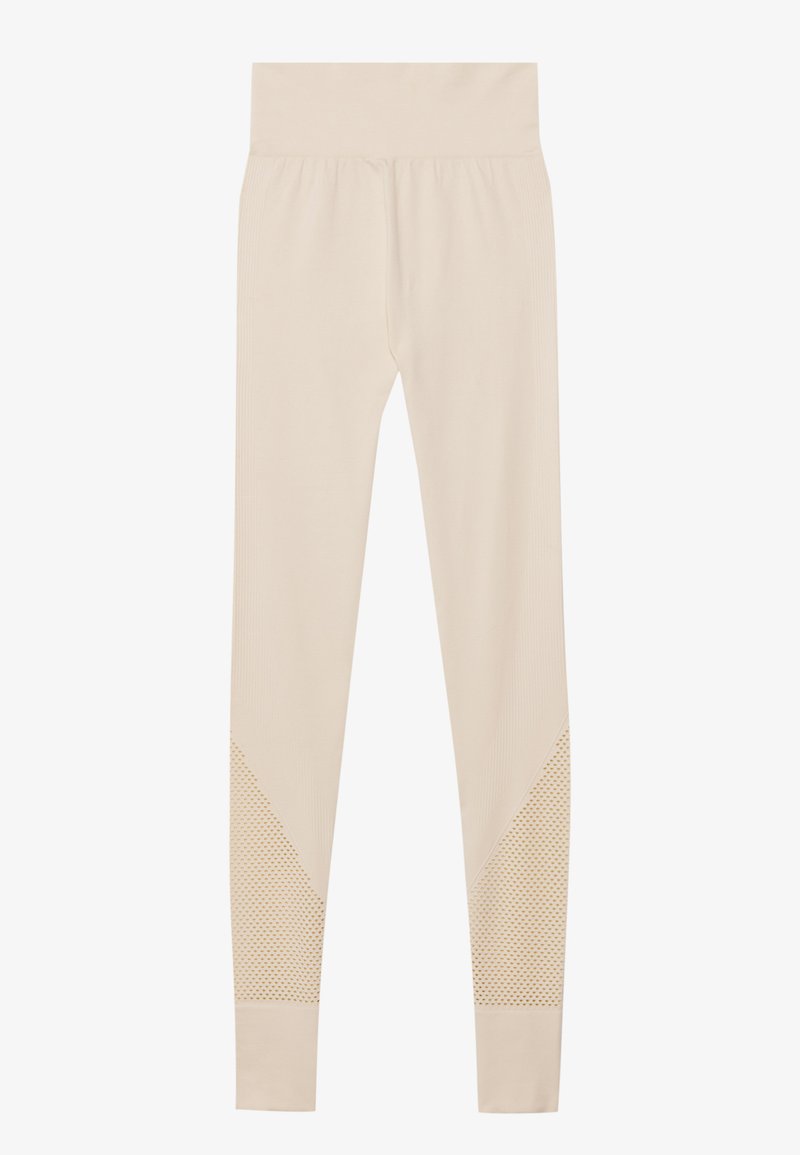 Beige høj-taljede sømløse leggings med teksturerede mesh-paneler på underbenene, designet til en tæt pasform og fleksibel bevægelse.
