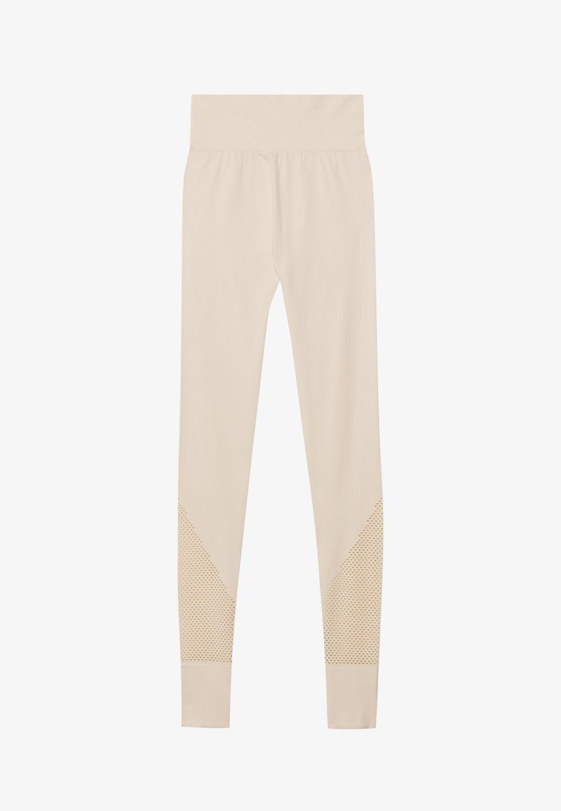 Beige høj-taljede sømløse leggings med teksturerede mesh-paneler på underbenene, designet til en tæt pasform og fleksibel bevægelse.