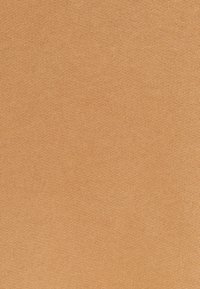 Katoenen stof in een zachte, warme beige kleur met een gladde textuur. Het materiaal heeft een subtiel, gelijkmatig breipatroon.