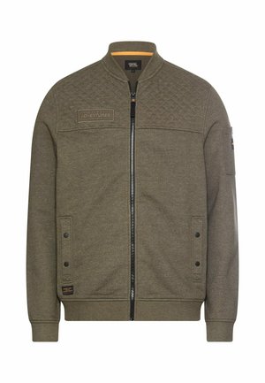 Olive green zip-up jacket with quilted details on shoulders, front pockets with button flaps, and a patch reading "Made for Daily Adventures."