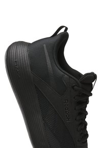 Black athletic shoe featuring a textured mesh upper, soft fabric collar, and ridged rubber sole with "DMX" branding.
