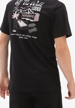 Black cotton t-shirt featuring white graphic design with palm trees, mountains, a pool, and text saying "Happy Hour is the Happiest Hour."