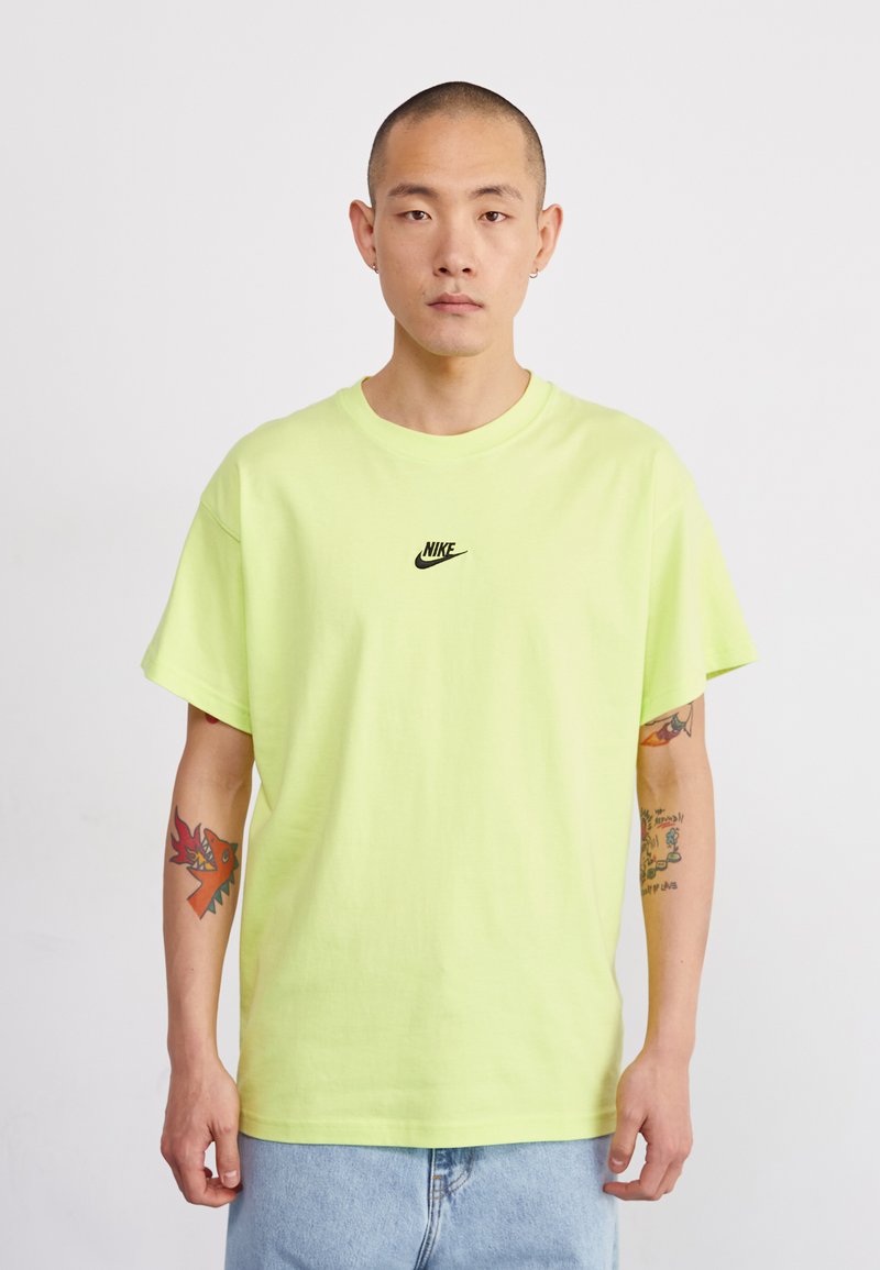 Neon sárga pamut póló laza szabással, apró fekete Nike logóval a mellen. Rövid ujjú és bordázott kerek nyakkivágású.