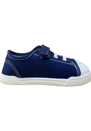 Zapatilla de lona en color azul marino con puntera de goma blanca y suela texturizada. Cuenta con cordones elásticos y una correa de velcro para ajuste. Logo de la marca en el lateral.