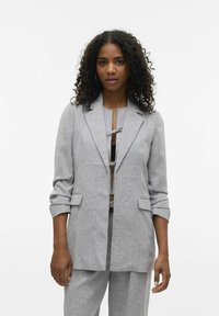 Blazer gris texturizado con solapas de muesca, cierre de botón y mangas arremangadas, combinado con una blusa a juego.