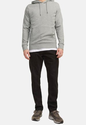 Grauer Kapuzenpullover mit Kängurutasche, kombiniert mit schwarzen Hosen und grau-braunen Sneakers. Lässiges Design mit lockerer Passform.