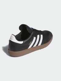 Czarne sneakersy z białymi paskami, zamszowym noskiem o teksturowanej powierzchni oraz gumową podeszwą. Zawierają logo na boku oraz wyściełany kołnierz.