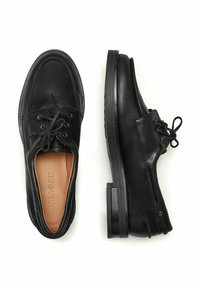 Černé kožené šněrovací společenské boty, přičemž jedna z nich zobrazuje horní pohled s názvem značky uvnitř, zatímco druhá zobrazuje boční profil na bílém pozadí.