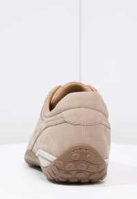 Baskets en suède gris avec une surface texturée, un arrière arrondi, des accents beiges et une semelle en caoutchouc à motifs. Dotées d'un col rembourré.