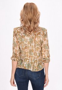 Hemdbluse mit Paisleymuster aus leichtem Stoff, mit einem lockeren Schnitt, 3/4-Ärmeln und einer gerafften Rückendetail, hauptsächlich in Erdtönen.