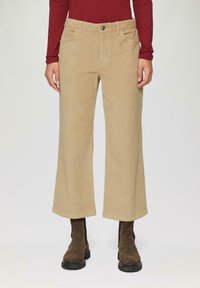 Beige corduroy wijde broek met knoopsluiting, voorzakken en een zachte textuur, aangevuld met bruine enkellaarsjes.