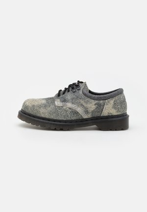 Chaussure à lacets en cuir gris texturé avec semelle noire et coutures blanches, vue de profil gauche sur fond blanc.