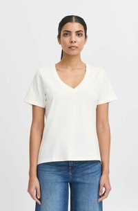 Soft white cotton t-shirt with short sleeves, V-neck design, relaxed fit, and smooth texture, paired with blue denim jeans.