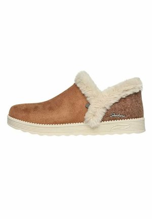 Brown suede slip-on shoe with a fluffy cream fur collar, featuring a textured sole and side logo accent. Simple, rounded design.