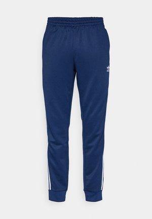 Pantaloni sportivi navy con cintura elastica, strisce laterali bianche e un piccolo logo bianco. Tessuto morbido con un design affusolato.