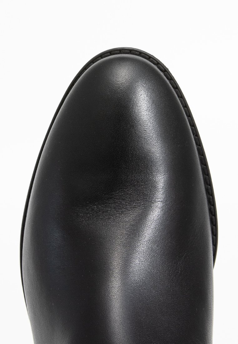Zwarte leren schoen met een soepele textuur en ronde neus. Heeft een dunne stiksels langs de rand, wat een klassieke uitstraling biedt.