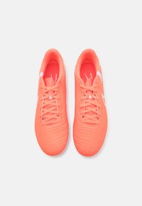 Bright neon pink soccer shoes with a textured, ridged synthetic upper and white accents. Features traditional lacing and padded collar.