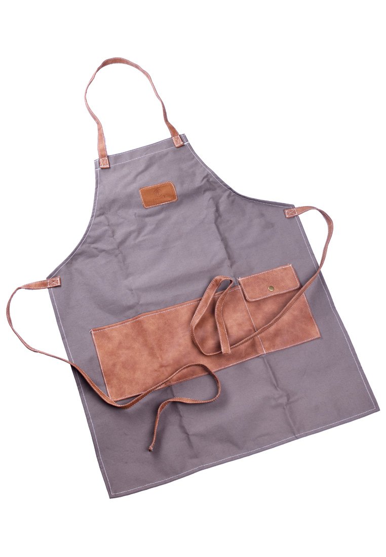 Tablier en toile gris avec des accents en cuir marron. Doté d'une poche avant, de bretelles réglables et de coutures contrastantes.