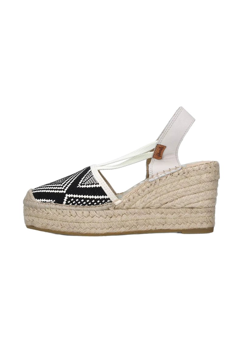 Infradito a zeppa in bianco e nero con motivo a fantasia, piattaforma in juta intrecciata e cinturino alla caviglia bianco con dettagli in pelle.