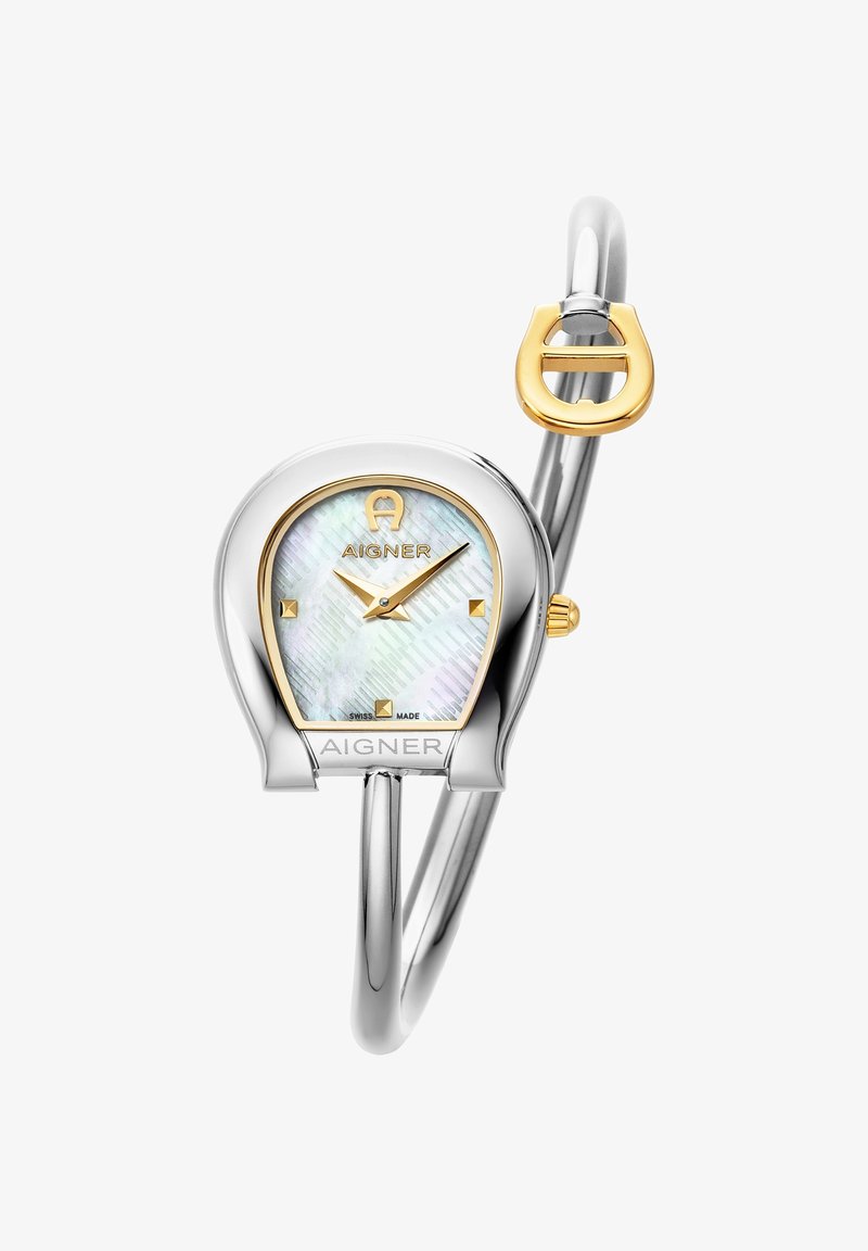 La montre-bracelet en argent et doré présente un boîtier courbé, un cadran irisé avec un motif en arêtes de poisson, et un design unique de bracelet ressemblant à un mors de cheval.